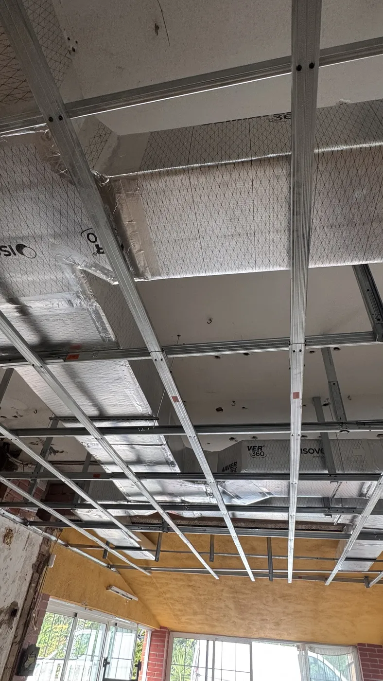 Conductos bajo estructura de falso techo en salón con ventanales